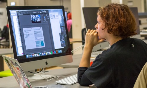 A student sat working at a desktop computer 