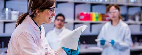 Female wearing lab coat and holding material swatch