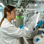 Female operating machinery wearing a lab coat